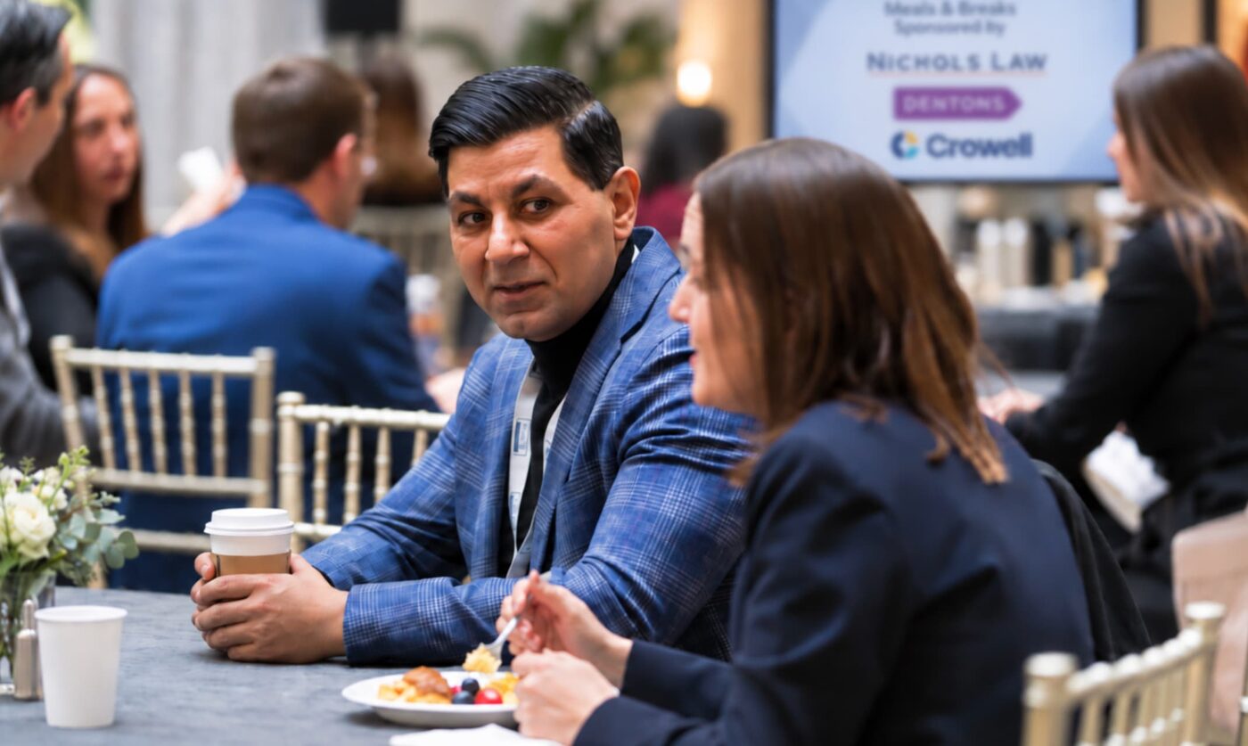 Attendees talking over coffee at a Pub K Annual Review break